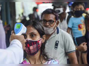 Mumbai: A BMC health worker does thermal screening of a passenger for COVID-19 t...