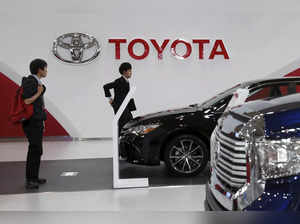 People walk under a logo of Toyota Motor Corp at the company's showroom in Tokyo