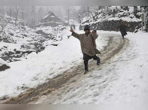 Srinagar: Boys play during a light snowfall, on the outskirts of Srinagar. Most ...