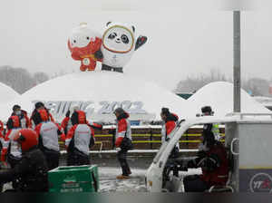 People walk in the snow near the Beijing 2022 Winter Olympics mascot Bing Dwen Dwen and Beijing 2022 Paralympics mascot Shuey Rhon Rhon in Beijing