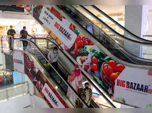 FILE PHOTO: People use an escalator as they exit a Future Group Big Bazaar retail store in Mumbai