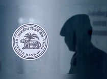 FILE PHOTO: A security guard's reflection is seen next to the logo of the Reserve Bank Of India (RBI) at the RBI headquarters in Mumbai