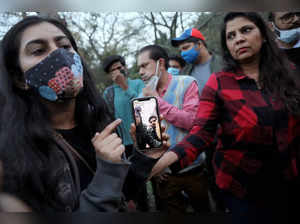 A girl shows her mobile phone on which she is on a video call with Indian students stuck in Ukraine, as family and friends of the students demand the Indian Government to evacuate the stranded students, near the Russian embassy in New Delhi
