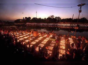 Ujjain: Devotees light lamps on the banks of the Kshipra river at an event title...