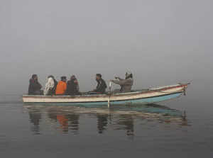 Lahore:  People ride in a boat on the Ravi River as heavy fog envelops the area,...
