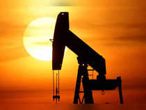 The sun sets behind an oil pump-jack outside Sommesous