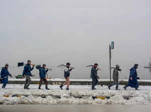 Srinagar: Srinagar Municipal Corporation (SMC) workers carrying shovels arrive t...