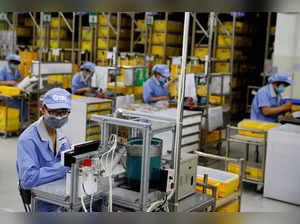 Employees wearing face masks work at a factory of the component maker SMC during a government organised tour of its facility following the outbreak of the coronavirus disease (COVID-19), in Beijing, China