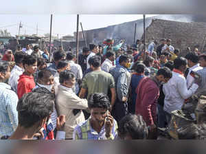 New Delhi: Locals gather after a fire broke out in shanties at Gokulpuri area, i...