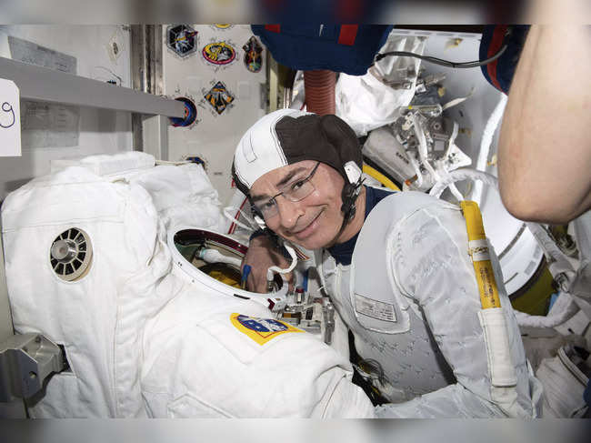 Mark Vande Hei inspects a spacesuit in preparation for a spacewalk at the International Space Station
