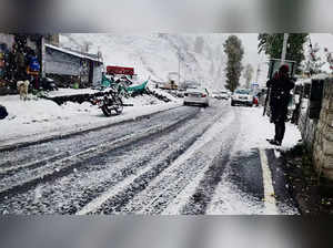 Keylong: Vehicles move slowly on a snow-covered road after fresh snowfall at Key...