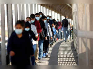 Migrants expelled from U.S. and sent back to Mexico walk across border bridge in Ciudad Juarez