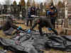 Bucha killings: Ukrainian Police officers inspect remains of victims