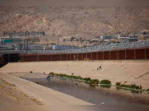 Asylum-seeking migrants cross the Rio Bravo river in El Paso, Texas