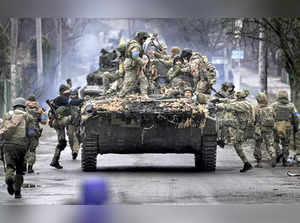 Bucha: Ukrainian servicemen climb on a fighting vehicle outside Kyiv, Ukraine. A...