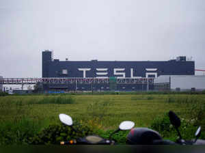FILE PHOTO: A Tesla sign is seen at its factory in Shanghai