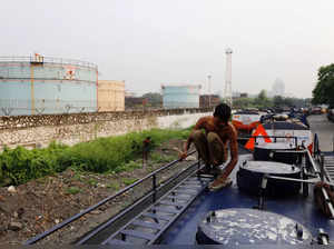 A man cleans an oil tanker parked outside a Hindustan Petroleum fuel depot in Mumbai