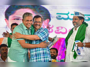 Bengaluru: Delhi Chief Minister Arvind Kejriwal hugs Farmer leader Kodihalli Cha...