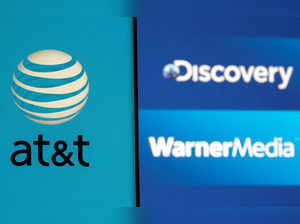 AT&T logo is seen on a smartphone in front of displayed Discovery and Warner Media logos in this illustration