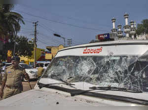 Hubballi: A security personnel stands next to a damaged vehicle after incidents ...