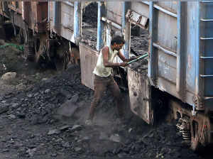 Nagpur: A worker unloads coal from a coal-laden goods train, at a railway statio...
