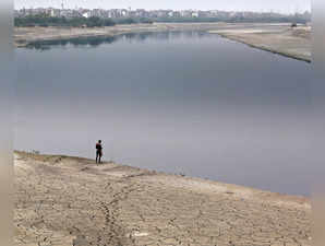 A man stands prior to taking bath in the Yamuna river on a hot summer day, in Delhi on Thursday.