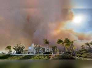 Smoke from a wildfire rises above a residential area in Laguna Niguel