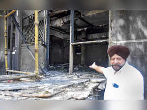 New Delhi: A man shows charred remains after a fire at Uphaar Cinema, which has ...