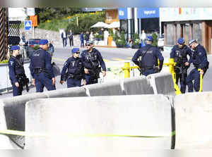 Swiss police officers stand behind a barrier  on the Promenade street in Davos