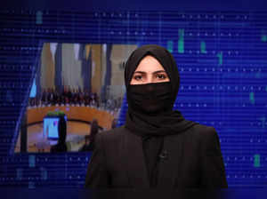 A female presenter for Tolo News, Sonia Niazi, while covering her face, works in a newsroom at Tolo TV station in Kabul