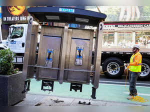 A worker removes the last public payphone near Times Square in New York