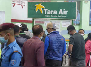 A signage of Tara Airlines is seen behind as a team of climbers prepare to leave...
