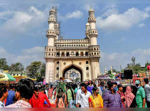 Hyderabad: People wearing face mask visit the historic Charminar, in Hyderabad. ...
