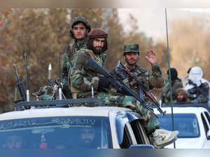 Members of Taliban sit on a military vehicle