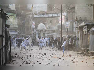 Kanpur: Members of the Muslim community throw stones during clashes after a Musl...