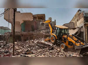 Kanpur: A bulldozer being used to demolish illegal houses to clear the land for ...