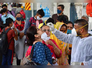 Mumbai: A healthcare worker collects swab sample of a passenger for Covid-19 tes...