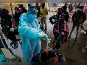 FILE PHOTO: Healthcare worker collects COVID-19 test swab samples from people at a railway station in New Delhi