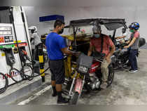 Motorists queue at a gas station a day before an oil price hike
