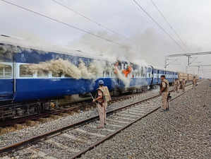 Ballia: Smoke billows from a train after it was set on fire by people protesting...