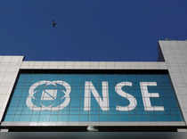 A bird flies past the logo of National Stock Exchange (NSE) installed on the facade of its building in Mumbai