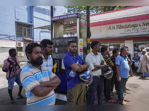 People wait to buy fuel at a fuel station in Colombo, Sri Lanka. Sri Lanka is se...