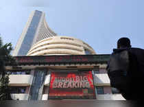 A man looks at a screen displaying budget news, on a facade of the Bombay Stock Exchange (BSE) building in Mumbai
