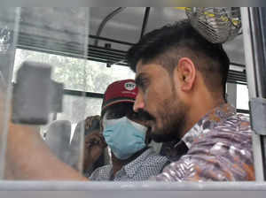 Mohammed Zubair sits in a police vehicle outside a court in New Delhi