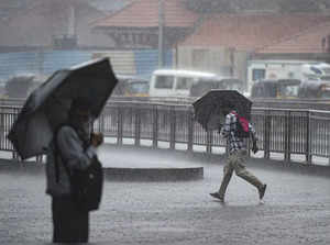 Mumbai: People hold umbrellas as it rains in Mumbai. (PTI Photo/Kunal Patil)(...