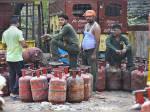 New Delhi: Workers arrange LPG cylinders at a godown in New Delhi. The price of ...