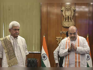 New Delhi: Union Home Minister Amit Shah with J & K Lt Governor Manoj Sinha hold...
