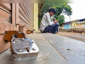 Solapur: A man sits near a closed shop during a strike called by traders against...