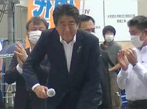 A man believe to be Tetsuya Yamagami, the suspect of shooting former Japanese Prime Minister Shinzo Abe, is seen behind Abe who is about to make a speech in Nara