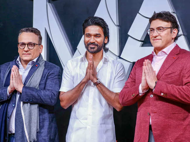 Hollywood film directors Joe Russo(L) and Anthony Russo(R) with Bollywood actor Dhanush pose for photos at a special screening of the Netflix movie 'The Gray Man', in Mumbai.